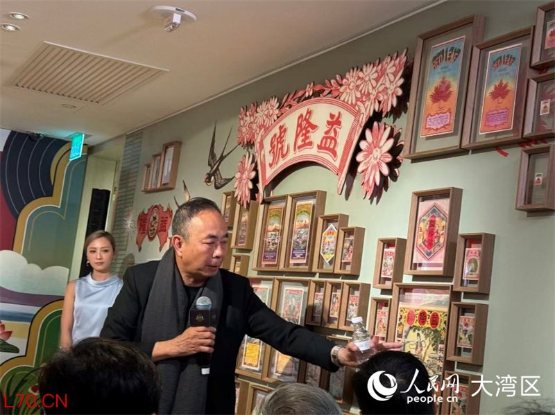 策展人吴卫鸣教授为观众讲解包装招纸展品。人民网富子梅摄